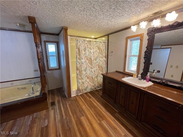 bathroom featuring ornamental molding, vanity, a textured ceiling, hardwood / wood-style flooring, and independent shower and bath