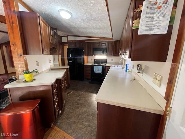 kitchen featuring a textured ceiling, sink, black appliances, dark tile patterned flooring, and lofted ceiling