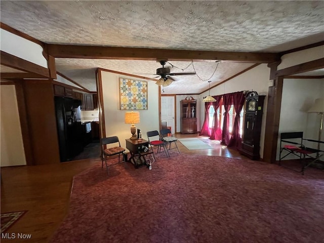 dining space featuring vaulted ceiling with beams, ceiling fan, and a textured ceiling