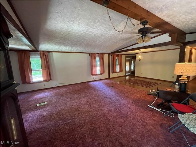 unfurnished living room with carpet, lofted ceiling with beams, ceiling fan, and a textured ceiling