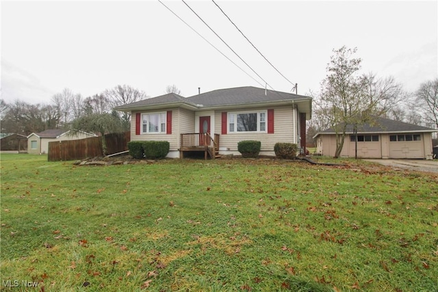 view of front facade featuring a garage, an outdoor structure, and a front yard