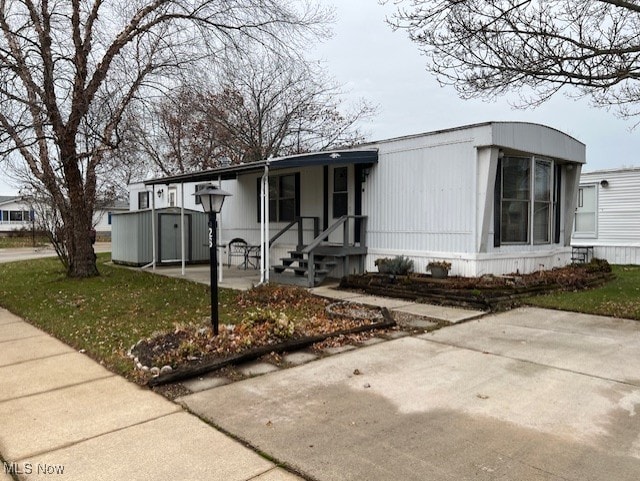 view of front of property featuring a front lawn and a storage unit