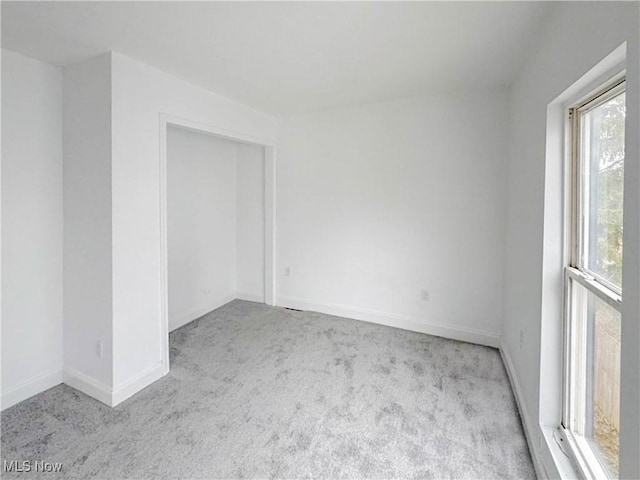 carpeted spare room with baseboards