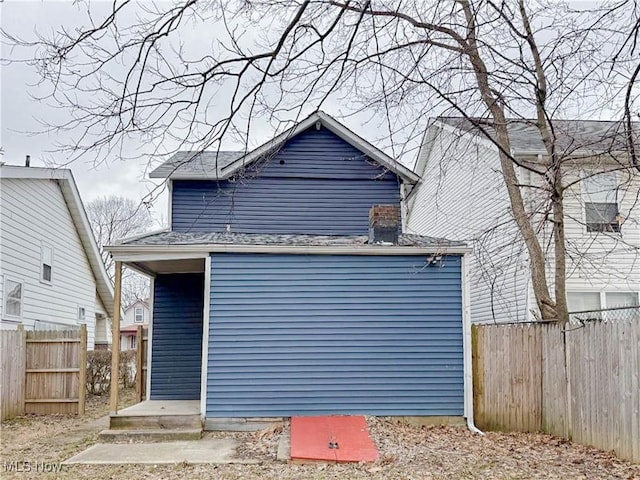 rear view of house featuring fence