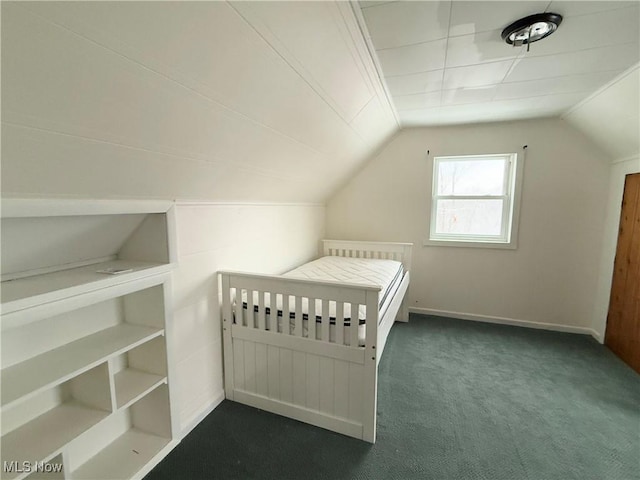 unfurnished bedroom with lofted ceiling and dark colored carpet