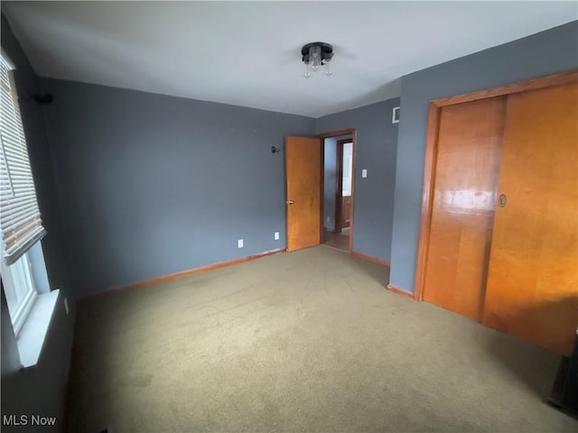 unfurnished bedroom featuring carpet and a closet