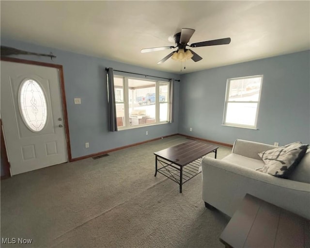 carpeted living room with ceiling fan and a healthy amount of sunlight