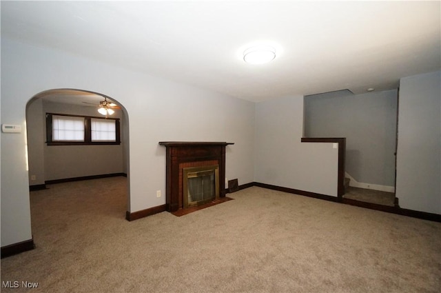 unfurnished living room with ceiling fan and light colored carpet