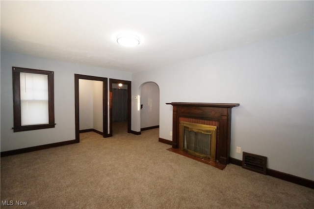 unfurnished living room with a fireplace and light carpet