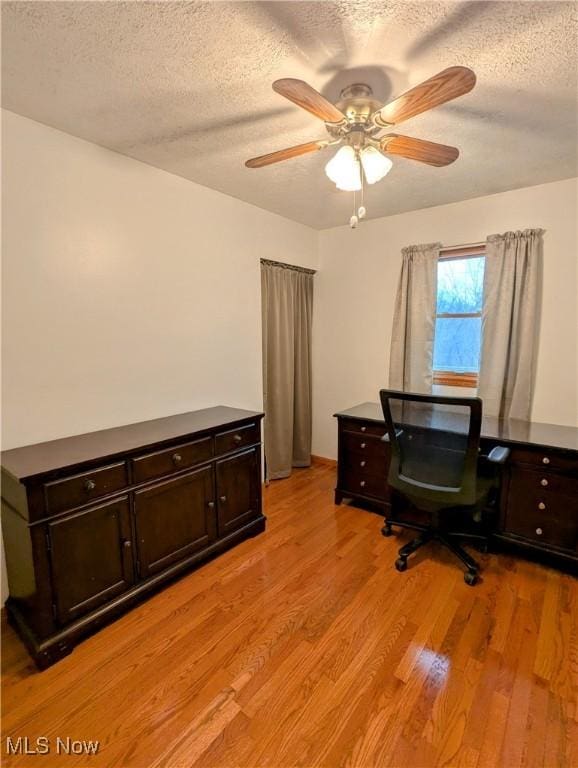 office space with ceiling fan, light wood-type flooring, and a textured ceiling