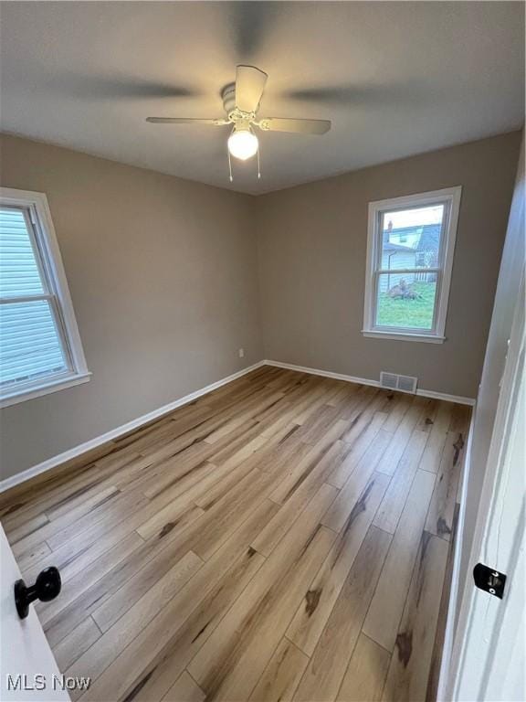 spare room featuring plenty of natural light, light hardwood / wood-style floors, and ceiling fan