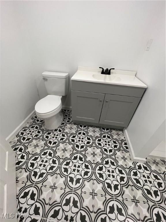 bathroom featuring tile patterned flooring, vanity, and toilet