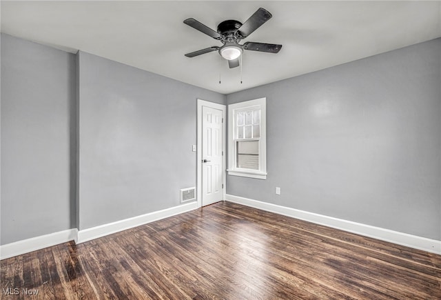 empty room featuring ceiling fan and dark wood-type flooring