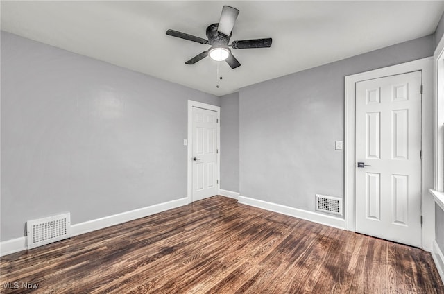 empty room with dark hardwood / wood-style floors and ceiling fan