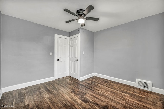 spare room with dark hardwood / wood-style floors and ceiling fan