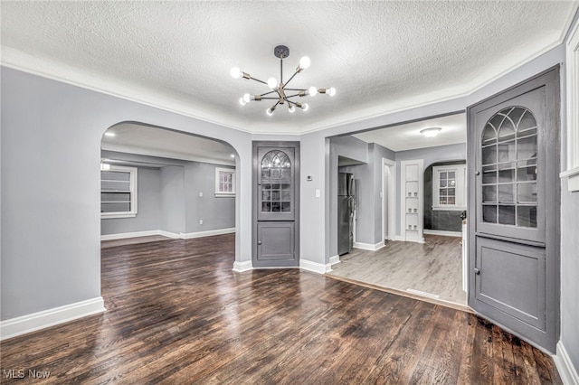 unfurnished living room with a textured ceiling, a chandelier, and dark hardwood / wood-style floors