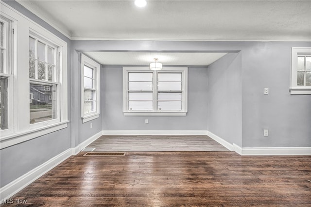 unfurnished room with dark hardwood / wood-style flooring and crown molding