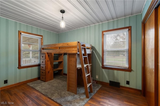 bedroom with dark wood-type flooring and a closet