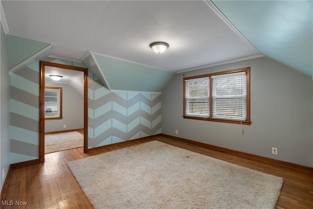 additional living space featuring wood-type flooring and vaulted ceiling