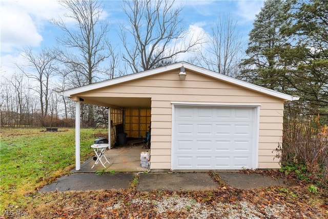 garage with a carport and a lawn