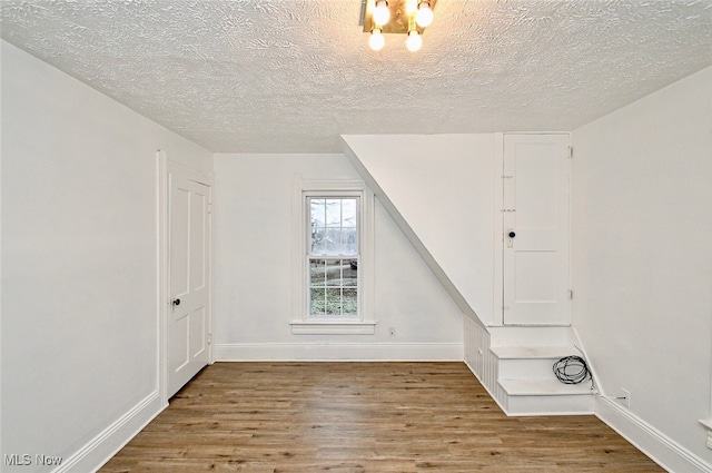 bonus room featuring a textured ceiling and light hardwood / wood-style flooring