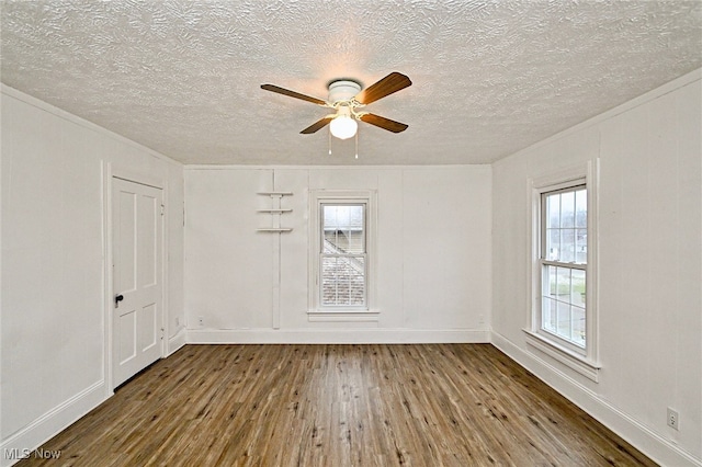 spare room featuring a textured ceiling, hardwood / wood-style flooring, ceiling fan, and crown molding