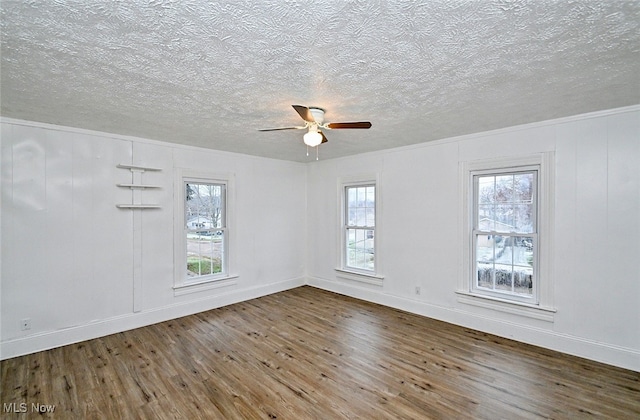 spare room featuring ceiling fan, crown molding, wood-type flooring, and a textured ceiling