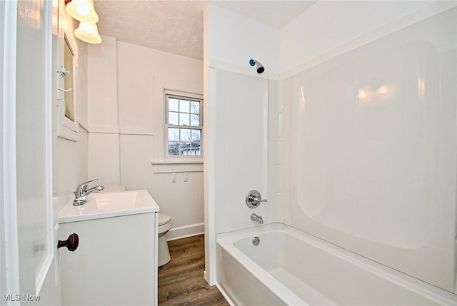 full bathroom featuring a textured ceiling, toilet, shower / washtub combination, vanity, and hardwood / wood-style flooring