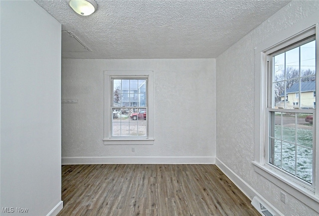 spare room with hardwood / wood-style flooring and a textured ceiling