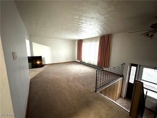 living room featuring carpet flooring, a textured ceiling, and a wealth of natural light