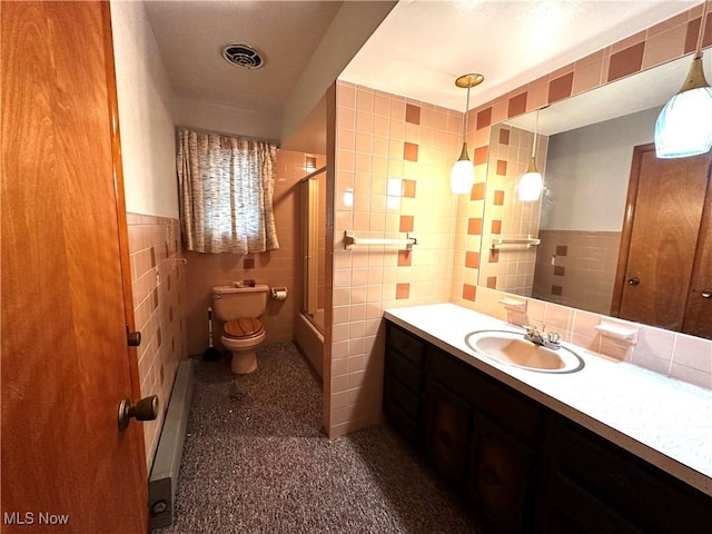 bathroom with vanity, a shower with door, toilet, tile walls, and baseboard heating