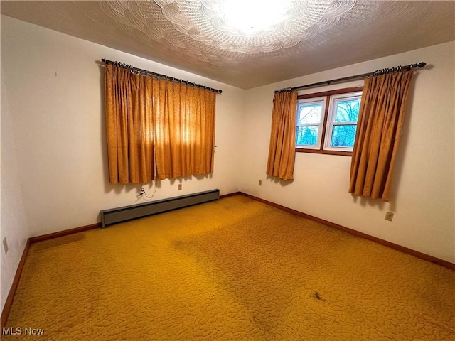 unfurnished room with a textured ceiling, carpet floors, and a baseboard heating unit