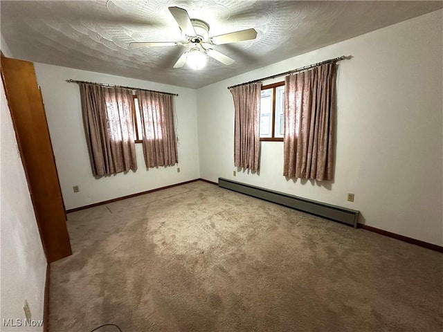 spare room with a textured ceiling, a baseboard radiator, ceiling fan, and light colored carpet