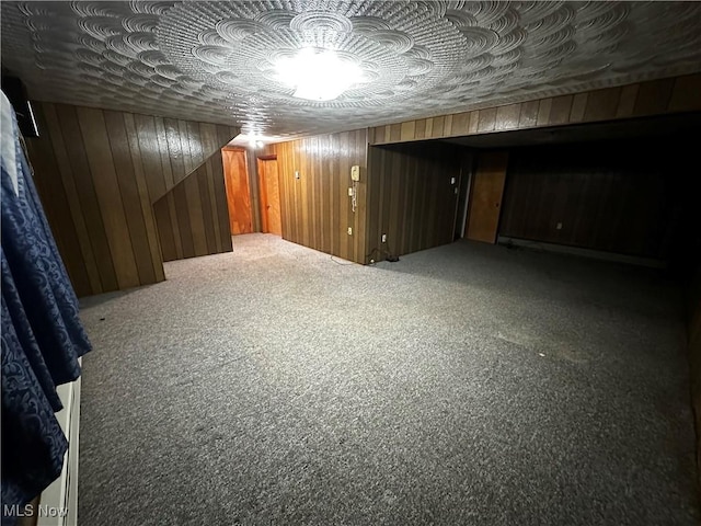 basement featuring carpet flooring and wood walls