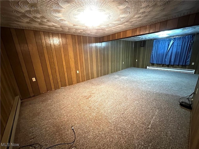 basement with carpet floors, baseboard heating, and wooden walls