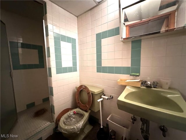 bathroom with toilet, sink, tile walls, and walk in shower