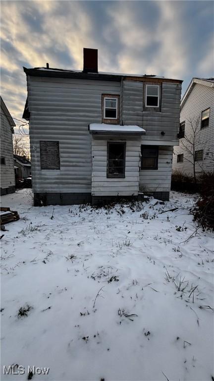 view of snow covered rear of property