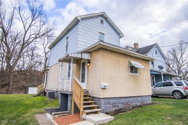 view of front of home featuring cooling unit and a front yard