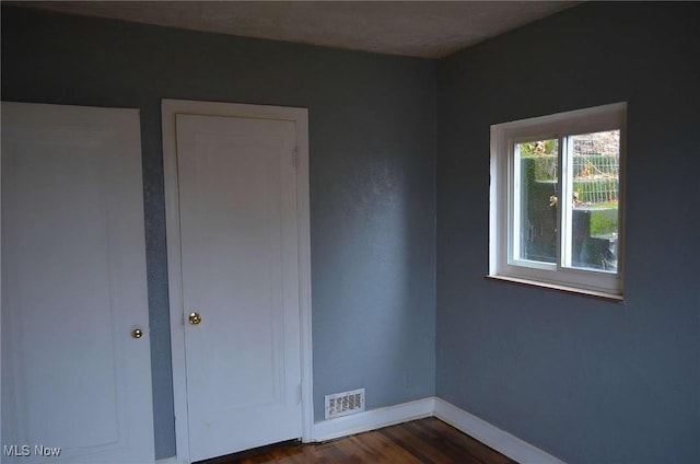 unfurnished bedroom with dark hardwood / wood-style flooring