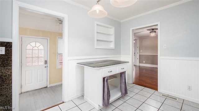 kitchen with ceiling fan, crown molding, pendant lighting, light hardwood / wood-style flooring, and white cabinets