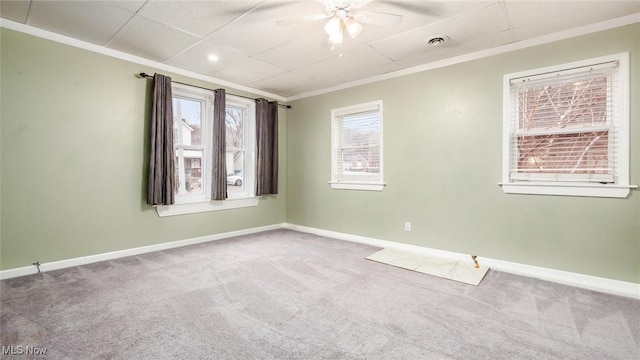 carpeted spare room with a wealth of natural light, crown molding, and ceiling fan