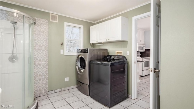 washroom featuring cabinets, independent washer and dryer, ornamental molding, and light tile patterned floors