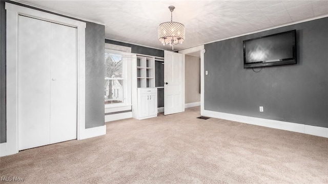 unfurnished bedroom with carpet and a notable chandelier