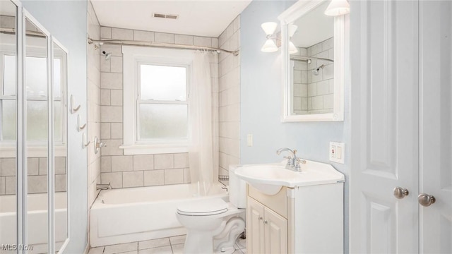 full bathroom featuring tile patterned floors, tiled shower / bath combo, toilet, and vanity