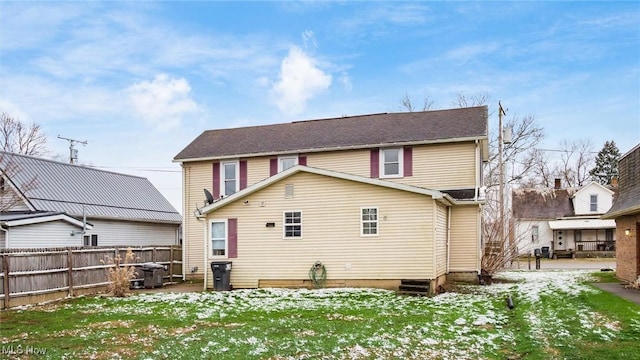 snow covered back of property featuring a lawn