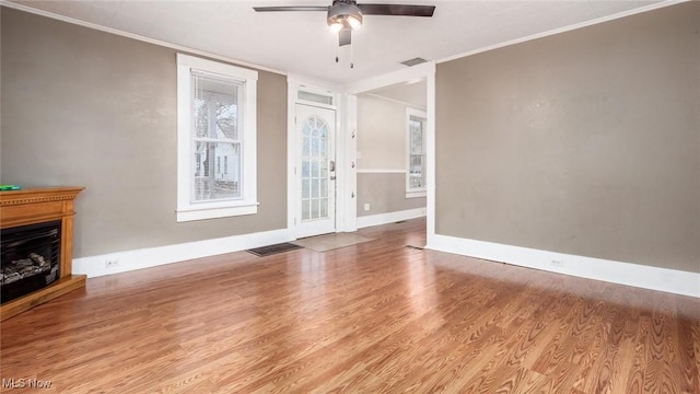 unfurnished living room featuring light hardwood / wood-style floors, ceiling fan, and ornamental molding