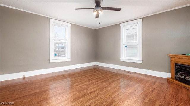 unfurnished living room with ceiling fan, hardwood / wood-style floors, and ornamental molding