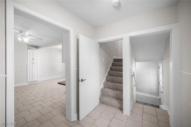 staircase featuring tile patterned floors and ceiling fan