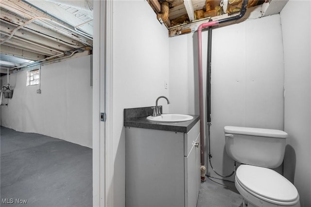 bathroom featuring concrete flooring, vanity, and toilet