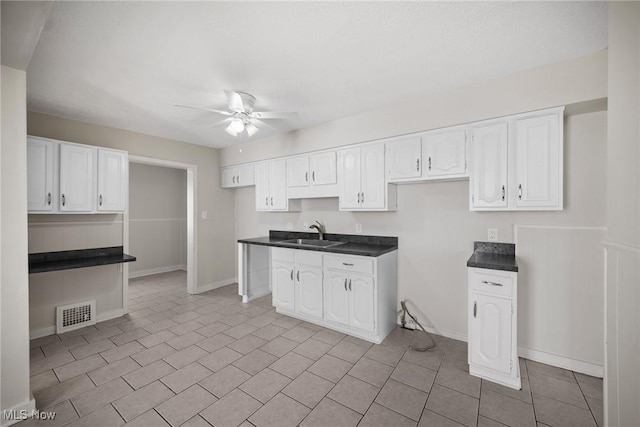 kitchen with white cabinetry, sink, and ceiling fan